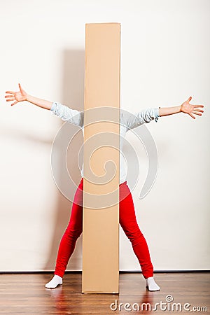 Happy woman moving into apartment carrying box. Stock Photo