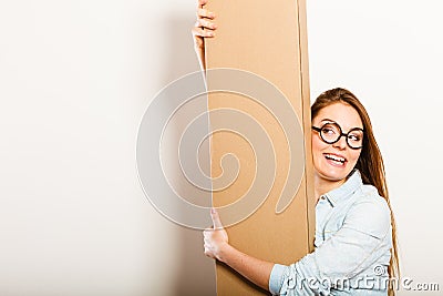 Happy woman moving into apartment carrying box. Stock Photo