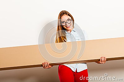 Happy woman moving into apartment carrying box. Stock Photo