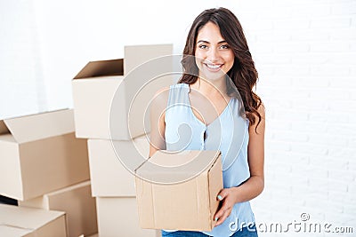 Happy woman moving in carrying carton boxes Stock Photo