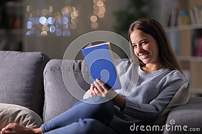 Happy woman in the night reading a paper book Stock Photo