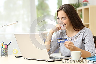 Happy woman paying with credit card on laptop Stock Photo