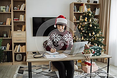 Caucasian remote employee starting day at home decorated with Christmas tree Stock Photo