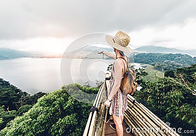 Happy woman pointing the horizon feeling free travelling the world on a inspirational background Stock Photo