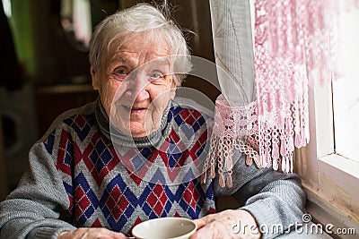 Happy woman portrait sitting at the table in the sweater. Stock Photo