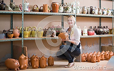 Happy woman potter carrying ceramic vessels Stock Photo