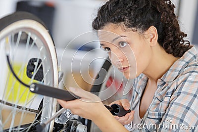 happy woman pumping up tire tyre with bike pump Stock Photo