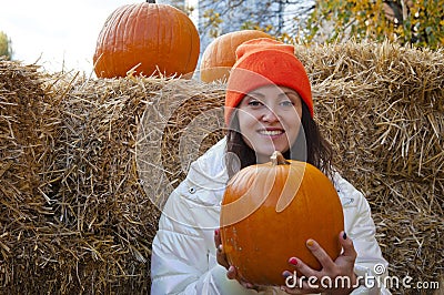 Happy woman with pumpkin. girl in orange hat with gourd on hay background. autumn harvest. happy halloween. copy space. farm and f Stock Photo