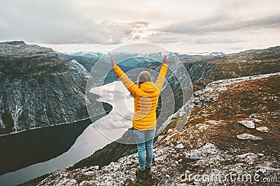 Happy woman raised hands on mountain summit Stock Photo