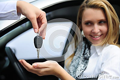 Happy woman receiving car key Stock Photo