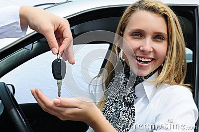 Happy woman receiving car key Stock Photo