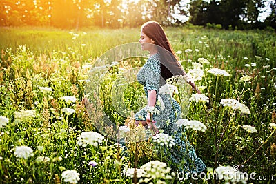 Happy woman running in a field among flowers Stock Photo