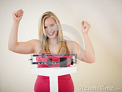 Happy woman on scale Stock Photo