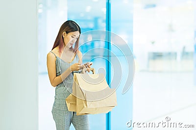 Happy woman with shopping bags enjoying in shopping and using sm Stock Photo