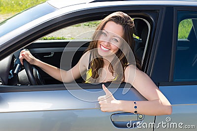 Happy woman showing good sign in the car. Stock Photo