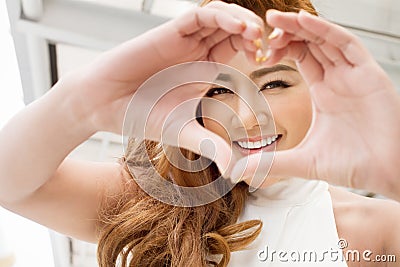 Happy woman showing heart hand sign to you Stock Photo