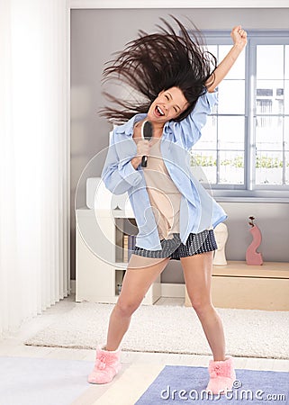 Happy woman singing to hairbrush in the morning Stock Photo