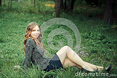 Happy woman sitting on grass Stock Photo