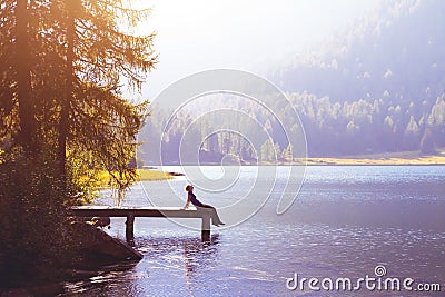 Happy woman sitting on the pier and smiling, happiness or inspiration concept Stock Photo