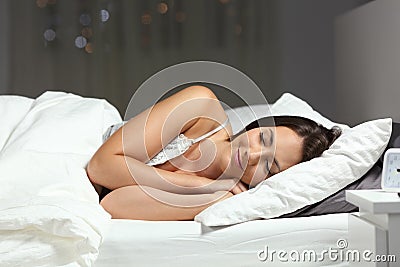 Happy woman sleeping on the bed in the night Stock Photo