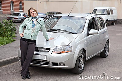 Happy woman standing in front of own car Stock Photo