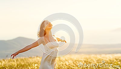 Happy woman standing with her back on sunset in nature iwith ope Stock Photo
