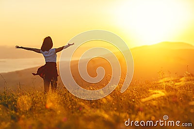 Happy woman standing with her back on sunset in nature iwith ope Stock Photo