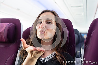 Happy woman tourist with pleasant anticipation on airplane Stock Photo