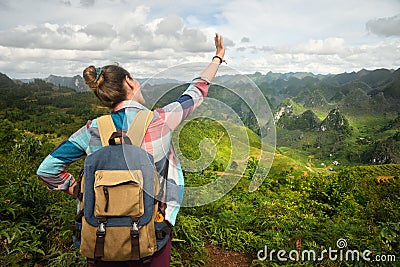 Happy woman traveler with backpack enjoying a beautiful view of Stock Photo