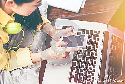 Happy woman using smart phone and laptop computer. Vintage effect tone. Stock Photo