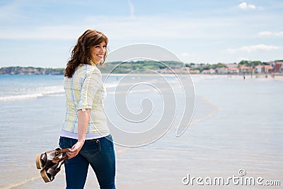 Happy woman walking along the seashore Stock Photo