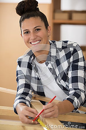happy woman with wooden plank and measuring tape Stock Photo