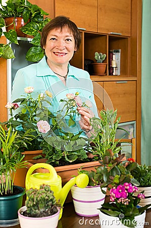 Happy woman working with fresh flowers in pots Stock Photo