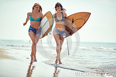 Womans with surfboard walking at beach.Sexy girls with surfboard at summer Stock Photo