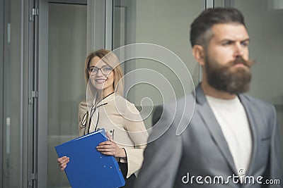 Happy woman with blurred man in foreground. Business woman in glasses hold file folder. secretary smile with office Stock Photo