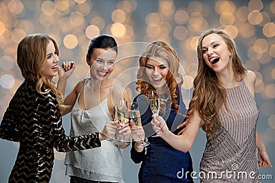 Happy women clinking champagne glasses over lights Stock Photo
