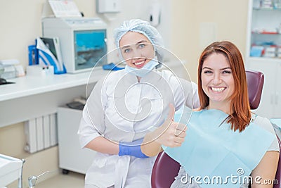 Happy women a dentist and patient after treating teeth at the dental office, smiling and looking towards the camera Stock Photo