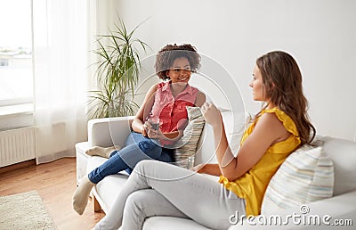 Happy women with drink talking gat home Stock Photo