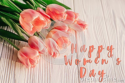 Happy women`s day text on pink tulips on white rustic wooden bac Stock Photo