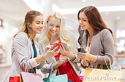 Happy women with smartphones and shopping bags Stock Photo