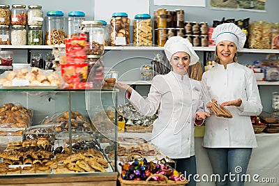 Happy women staff offering sweets Stock Photo