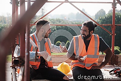 Happy Workers In Construction Site During Lunch Break Stock Photo