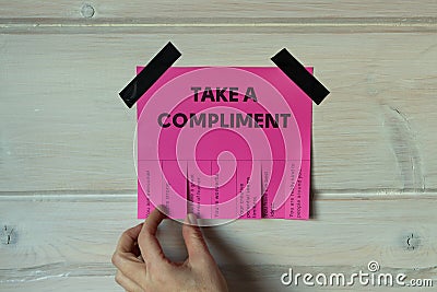 Happy World Compliment Day. Take a compliment. Pink wall paper sticker with text of popular compliments for beautiful lady pasted Stock Photo