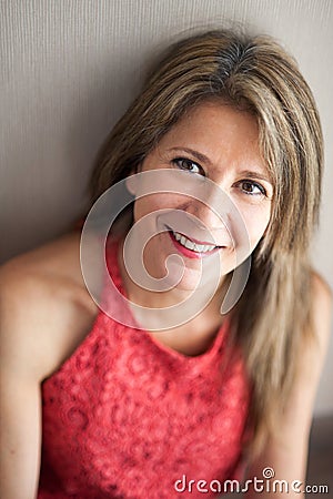 Happy 50 Year Old Woman Leaning Against Wall Stock Photo