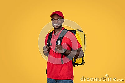 Happy young african american deliveryman in red uniform with big backpack, enjoy work Stock Photo