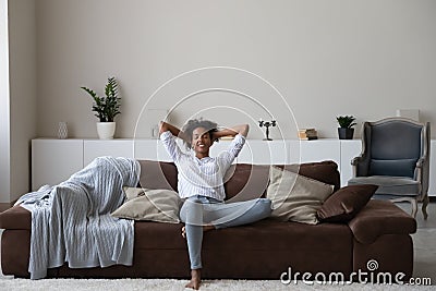 Calm biracial woman relax on cozy couch at home Stock Photo