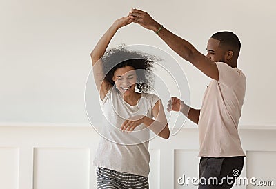 Happy young african couple holding hands dancing laughing at home Stock Photo
