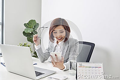 Happy young asian business woman finished her work at workplace Stock Photo