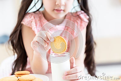 happy young asian girl eat milk cookie biscuit with dairy fresh milk for breakfast in morning before go to study at school Stock Photo