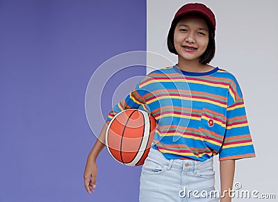Happy young asian girl palying basketball with pastel background Stock Photo